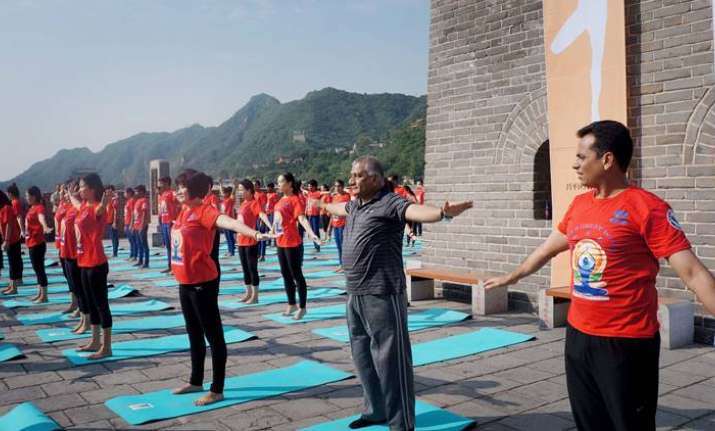 Indians and Chinese practice yoga at Great Wall