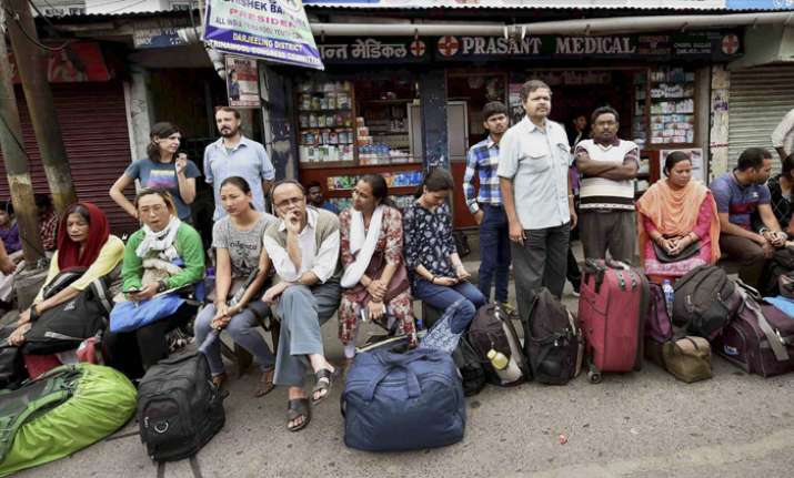 Stranded tourists wait at a bus stand in Darjeeling