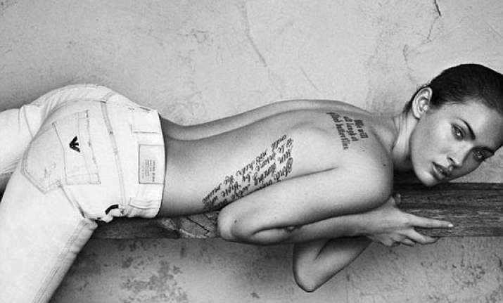 megan shows off tattoos on her bare back wearing armani