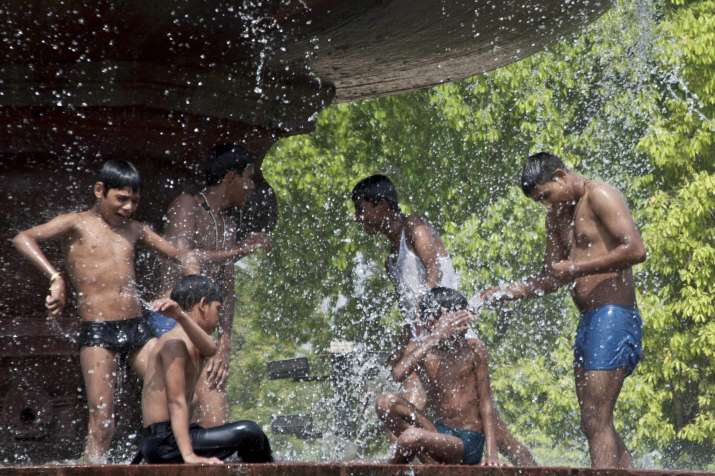 Youngsters splash water at a fountain near India Gate to