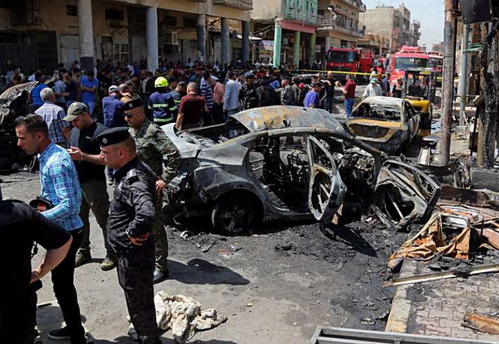Security forces and civilians at the site of a deadly bomb