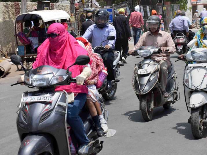 People cover their faces to protect themselves from heat in