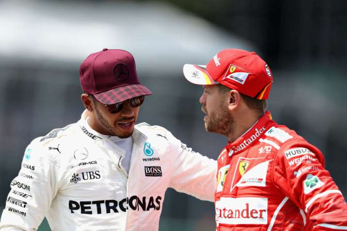 Lewis Hamilton of Great Britain talks with Sebastian Vettel