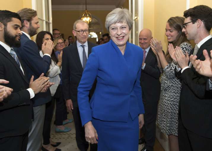 Britain's PM Theresa May applauded by staff as she returns