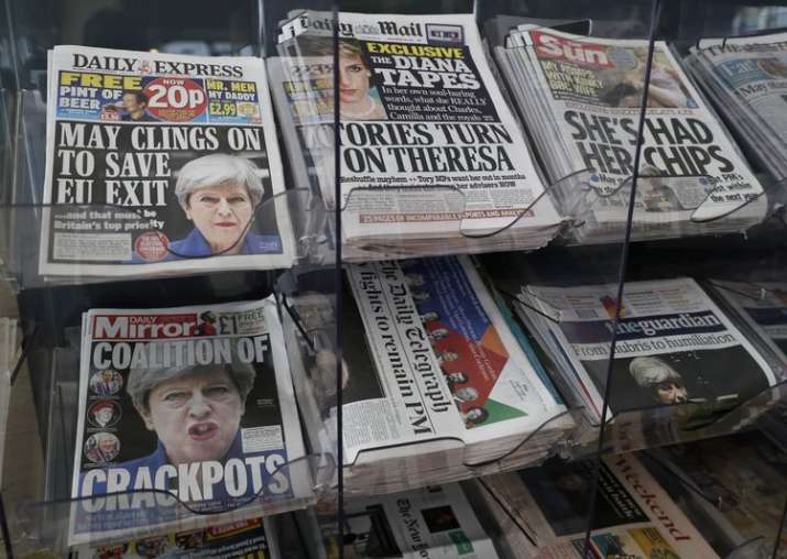 Newspapers fronted with photos of May are displayed at a