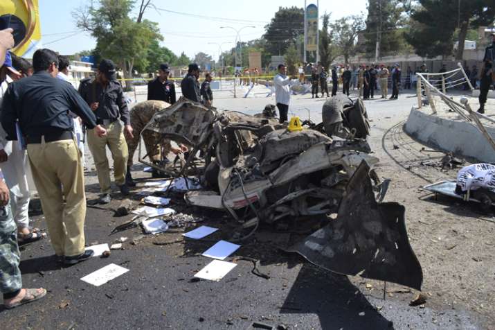 Pakistani police officers examine the site of an explosion