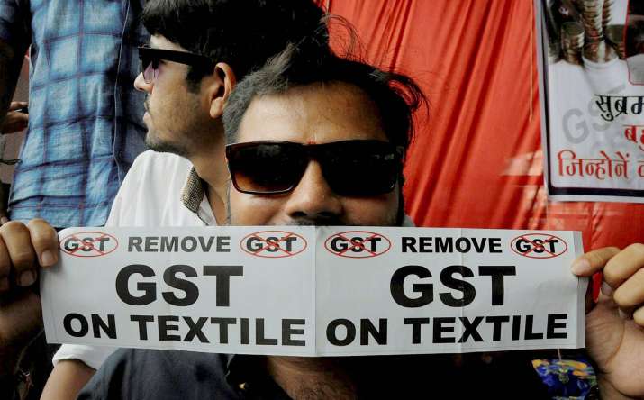 A textile trader with anti-GST poster during a protest in