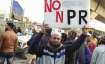 A protestor holds a banner at Jafrabad protest site on