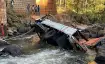 People view a truck that fell off the Gelan Bridge as it