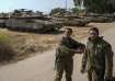 Israeli soldiers near their tanks in an area near the