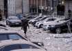 A police officer walks at the parking with damaged cars in
