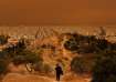 A man makes his way at a hill as African dust from the desert of Sahara covers the city of Athens