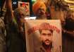 Indian Sikhs shout slogans against Pakistan as they display photographs of Sarabjit Singh, centre, w