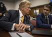 Former President Donald Trump sits in a courtroom next to his lawyer Todd Blanche before the start o