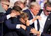 Republican presidential candidate former President Donald Trump is helped off the stage by U.S. Secr
