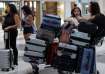 Women stand near their luggage in front of the Middle East Airlines (MEA) offices at the Beirut–Rafi