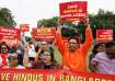 People hold signs at a protest against violence targeting Bangladesh's minority Hindus, after former