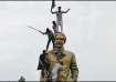 People climb the statue of Sheikh Mujibur Rahman at the