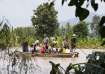 Local residents carrying food on their cart wade through a