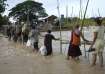 Local residents wade through flooded water at a broken bridge, in Naypyitaw, Myanmar.