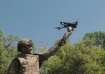 A military personnel posing with drone