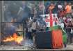 Demonstrators toss a trash bin during an anti-immigration