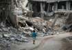 A child walks through the destruction left by the Israeli air and ground offensive on Khan Younis, G