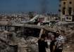 People stand amid damage caused by Israeli airstrikes in