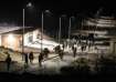 Israeli soldiers walk near the scene where a drone from