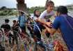 Migrants from Venezuela make their way through the razor wire after crossing the Rio Grande into the