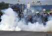 Police officers fire tear gas to disperse the supporters of