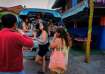 Tourists talk to a bar owner in Vang Vieng, Laos