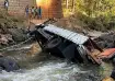 People view a truck that fell off the Gelan Bridge as it