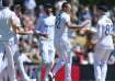 Brydon Carse celebrates a wicket with his teammates.