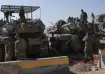 Israeli soldiers work in a staging area on the Israel-Gaza