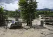 A truck and structures stand partially submerged in a thick