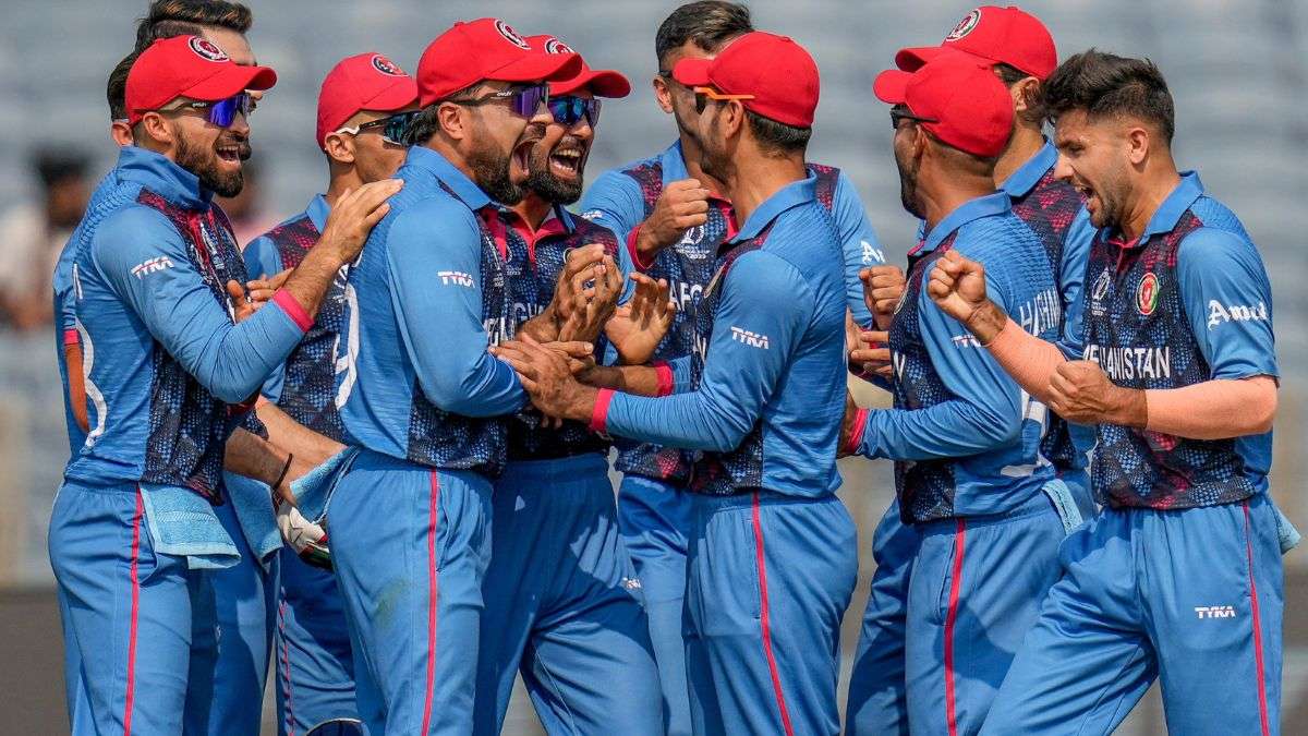 Fazalhaq Farooqi celebrates with fellow teammates at MCA Stadium in Pune.