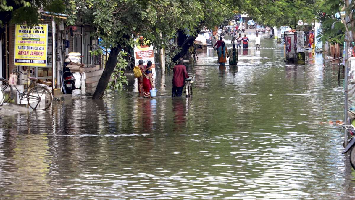 Locals wade through a waterlogged street after heavy rain,