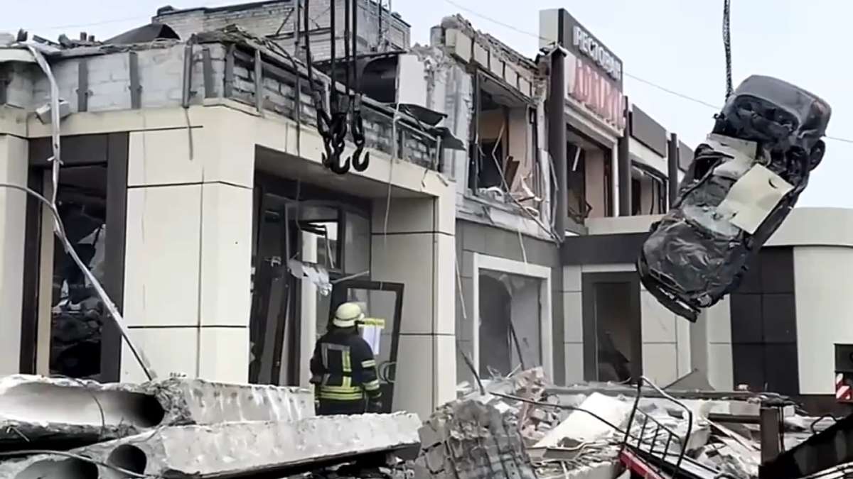 Russian Emergency Ministry employees work at the side of a collapsed bakery after an attack by Ukrai