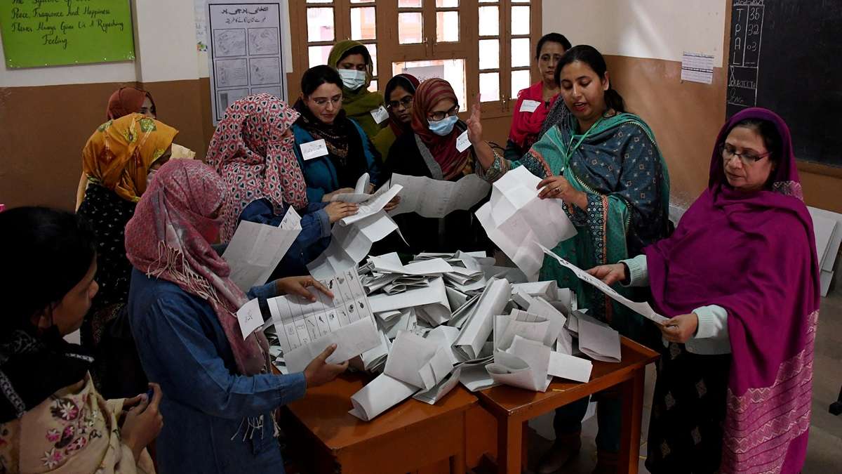 Polling staff count ballots after the end of the voting at