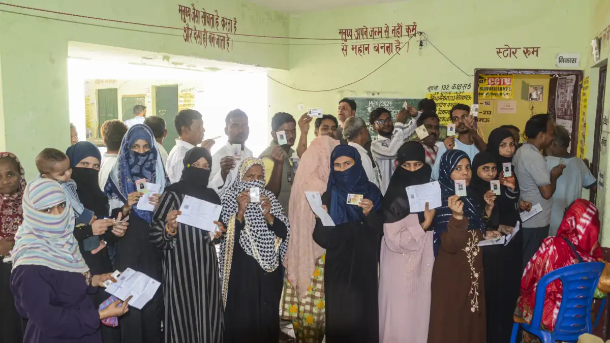 Voters show their identification cards while waiting to