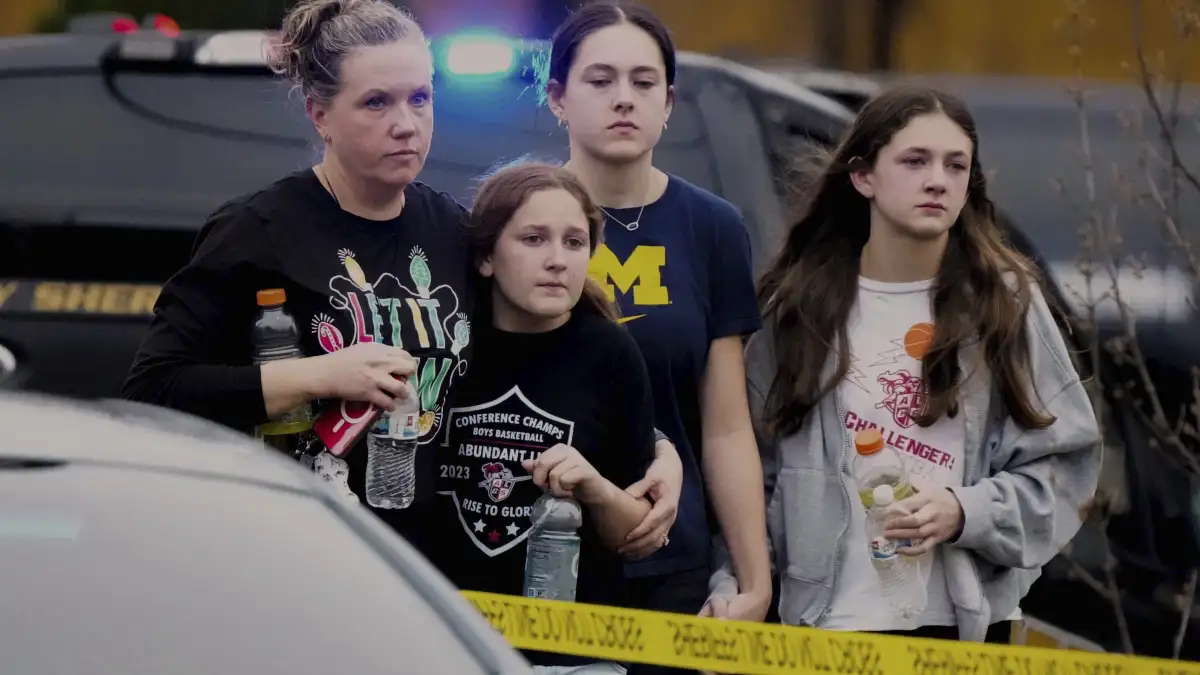 Students walk to a bus as they leave the shelter following a shooting at the Abundant Life Christian