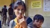 A voter shows her finger marked with indelible ink after