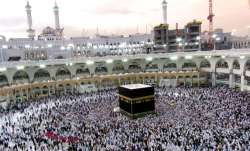 Muslim pilgrims walk around the Kaaba, the cubic building
