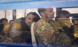 Ukrainian servicemen sit in a bus after they were evacuated