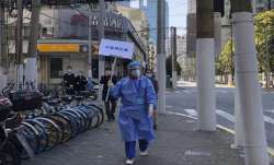 A worker in protective gear holds a sign which reads "Do