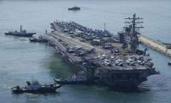 The US carrier USS Ronald Reagan is escorted as it arrives