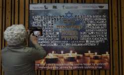 A woman photographs a poster in memory of members of the