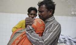 People mourn next to the body of their family member, who