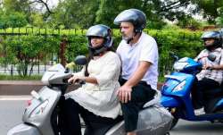 Congress leader Rahul Gandhi rides pillion on a student's